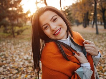 Junge Frau ist herbstlich angezogen und ist im Wald  | © GettyImages/Tanja Ristic