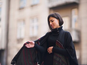 Junge Frau mit einem Cape | © Getty Images/SrdjanPav