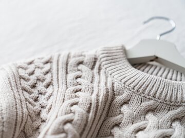 Wollpullover mit Zopfstrickmuster auf Kleiderbügel | © AdobeStock/22Imagesstudio