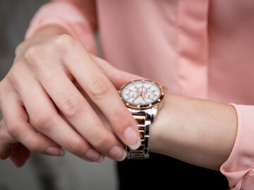 Hand umfasst Armbanduhr | © Getty Images/Westend61