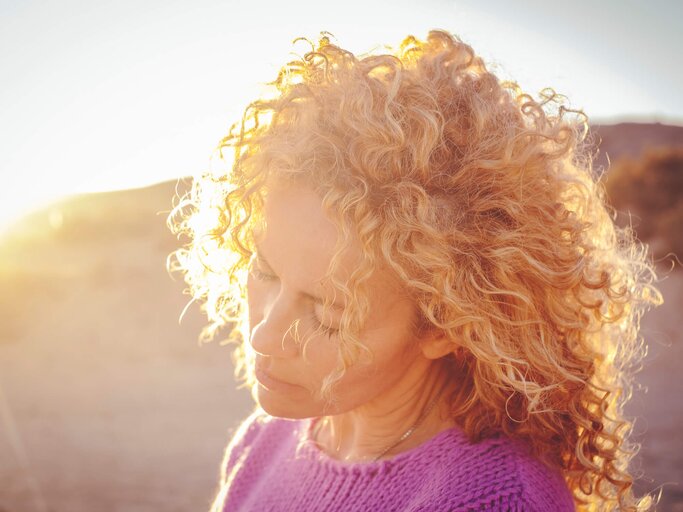 Frau mit schönen Locken im Sommer | © Getty Images/simonapilolla