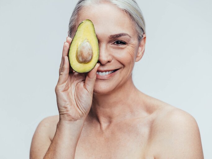 Schöne reife Frau mit Avocado in der Hand | © gettyimages.de / jacoblund