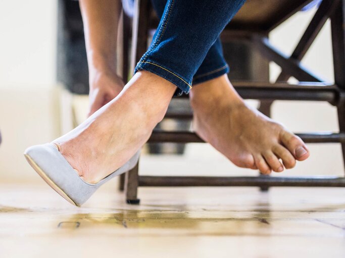 Frau zieht High Heel aus | © gettyimages.de / Westend61