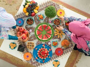 Buntes Obst und Gemüse auf eine, Tisch. Zwei Frauen mit Kopftüchern richten es an. | © Jasmin Merdan, Getty Images