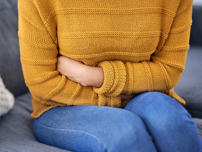 Frau hält sich den Bauch, weil sie Blähungen hat | © gettyimages.de / LaylaBird