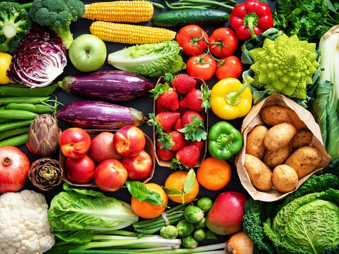 Lebensmittelhintergrund mit einem Sortiment an frischem Bio-Obst und -Gemüse | © Getty Images/AlexRaths