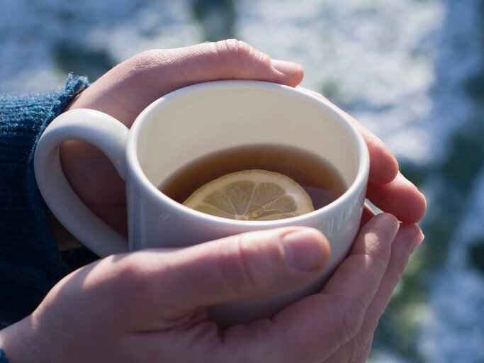 Hände, die eine Tasse mit heißer Zitrone halten | © gettyimages.de | Richard Clark