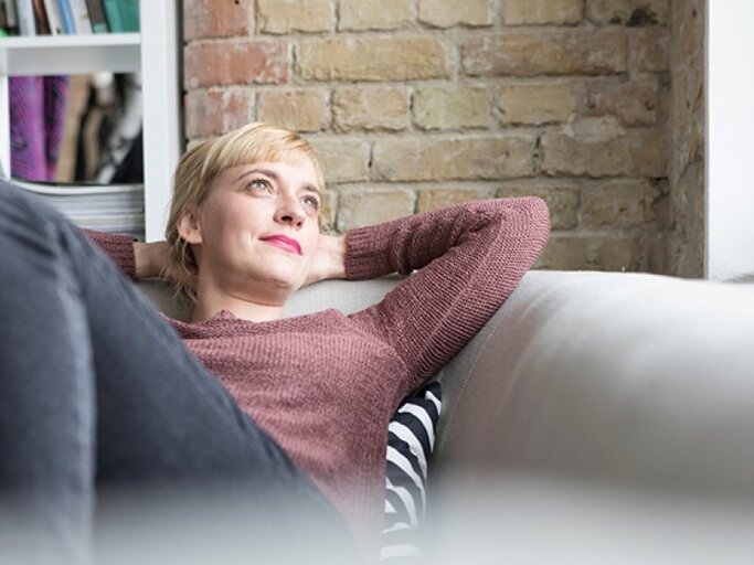 Frau liegt auf dem Sofa | © Westend61, Getty Images