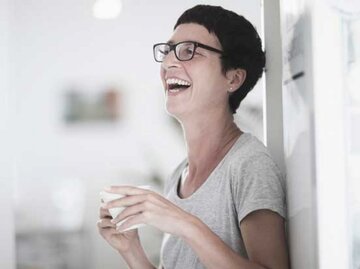 Lachende Frau mit Kurzhaarschnitt und Brille | © Sigrid Gombert, Getty Images