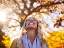 Frau blickt glücklich in die Herbstsonne | © gettyimages.de / Wavebreakmedia