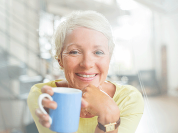 Frau mit kurzen Haaren die eine Tasse  | © Tom Merton, Getty Images