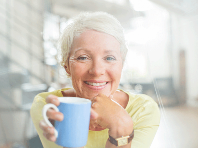Frau mit kurzen Haaren die eine Tasse  | © Tom Merton, Getty Images