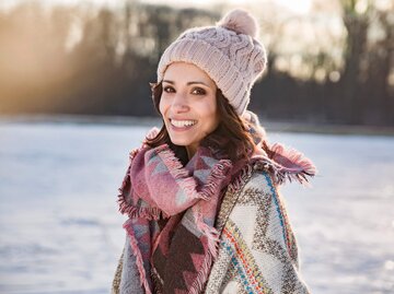 Frau trägt eine Mütze in einer Winterlandschaft | © gettyimages.de /Westend61