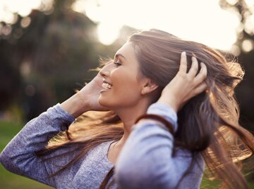 Frau fasst sich in die Haare | © iStock | PeopleImages