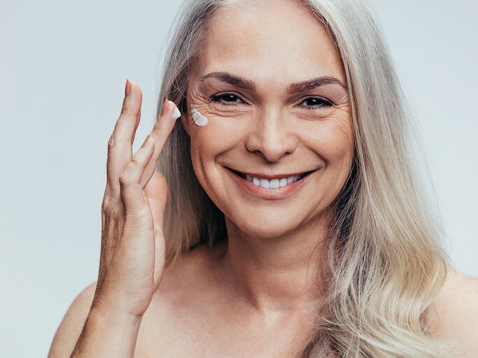 Reife Frau trägt Anti-Aging-Creme auf | © iStock | jacoblund