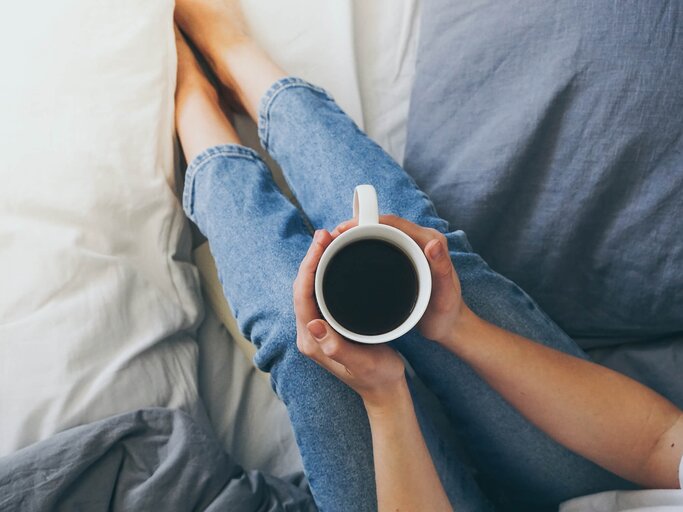 Frau trinkt Kaffee im Bett | © iStock | Luisa Whr