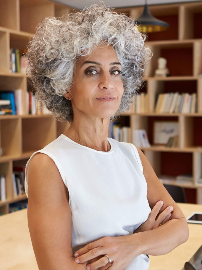 Frau trägt eine voluminöse Lockenfrisur mit grauen Haaren | © iStock | monkeybusinessimages