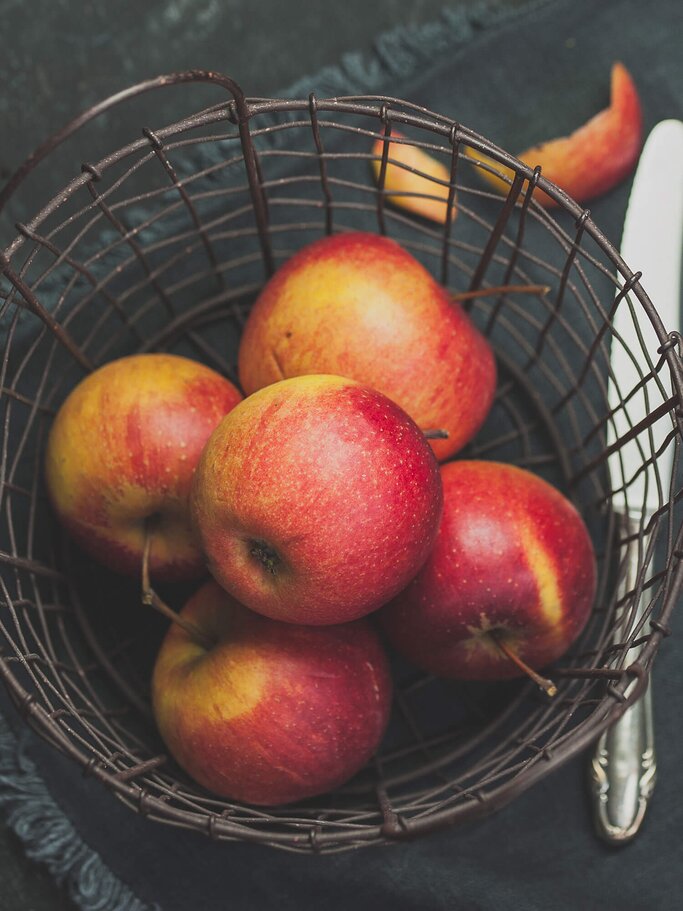 Äpfel der Sorte Rubinette in einem Obstkorb | © iStock | stefanie Metzger