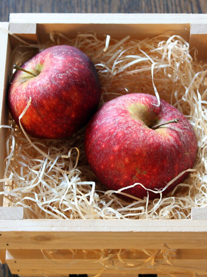 Zwei rote Äpfel der Sorte Ingrid Marie im Holzkorb | © iStock | SwedePix