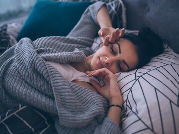 Junge Frau wacht im Bett auf und reibt sich die Augen | © iStock | Milan_Jovic
