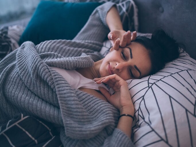Junge Frau wacht im Bett auf und reibt sich die Augen | © iStock | Milan_Jovic