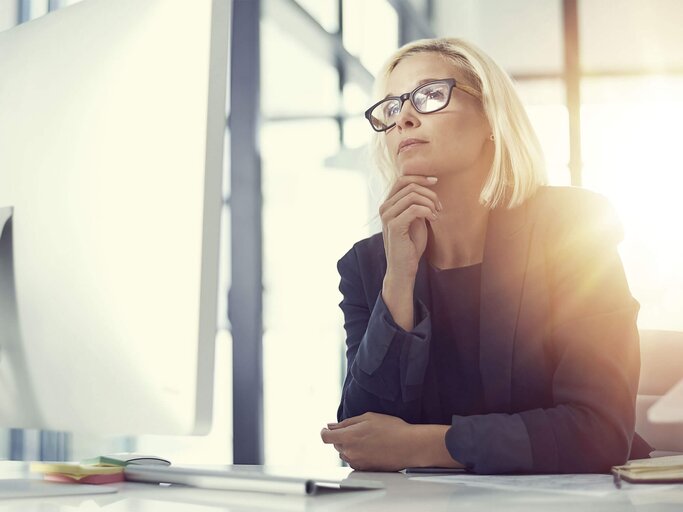 Frau sitzt vor einem PC und testet ihr Allgemeinwissen. | © iStock.com / Tinpixels