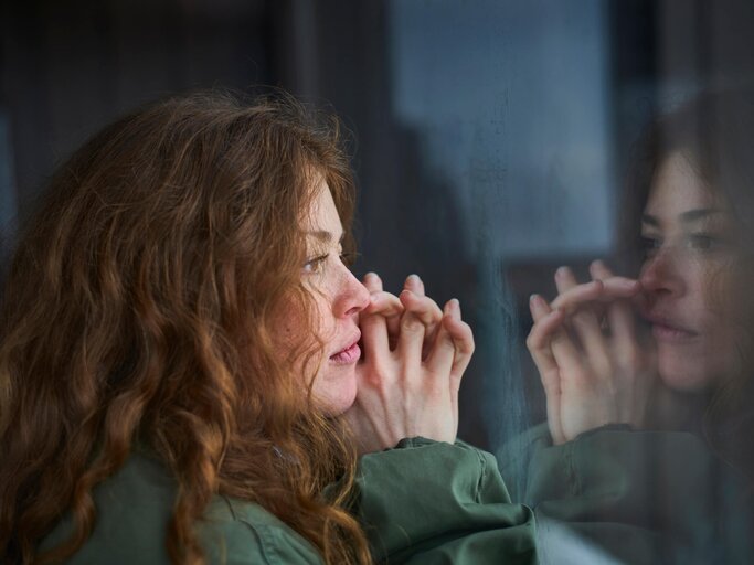 Frau blickt nachdenklich aus dem Fenster | © gettyimages.de /  Justin Case