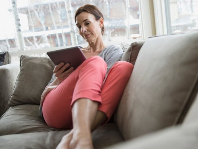 Ältere Frau auf der Couch mit einem iPad.  | © Getty Images | Hero Images