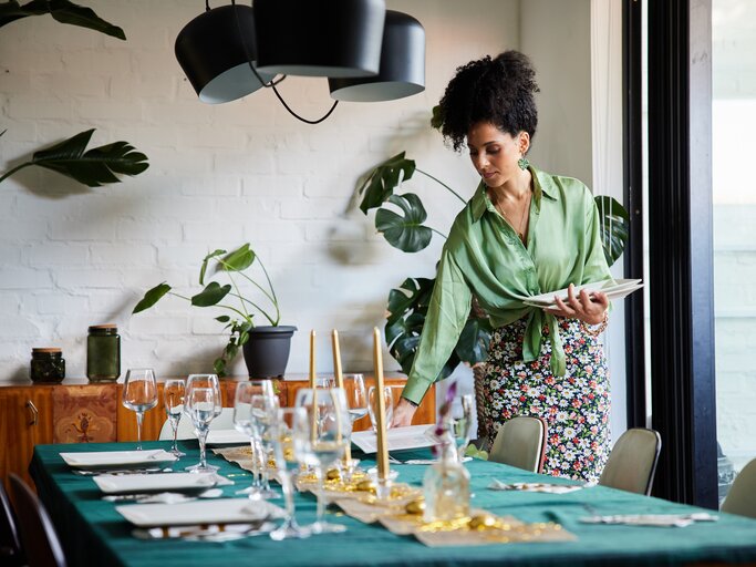 Schöne Frau deckt den Tisch | © Getty Images/Goodboy Picture Company