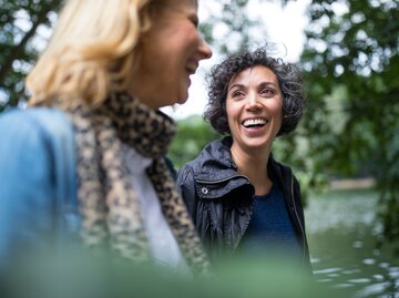 Zwei Freundinnen unterhalten sich bei einem Spaziergang im Wald | © Getty Images/alvarez