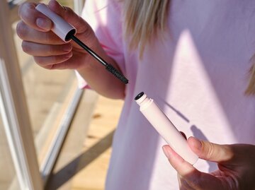 Frau öffnet Wimperntusche | © Getty Images/Iuliia Pilipeichenko