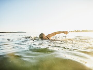 Frau geht im See schwimmen | © Getty Images/Thomas Barwick