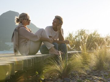 Frau und Mann unterhalten sich im Sommer | © GettyImages/	Ascent/PKS Media Inc.