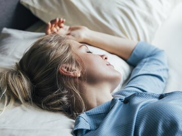 Frau schläft im Seiden-Schlafanzug | © GettyImages/	FreshSplash