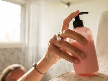Frau benutzt Shampoo in der Dusche | © Getty Images/Mystockimages