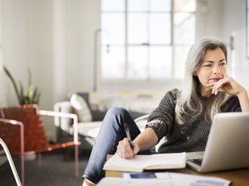 Frau sitzt am Laptop und arbeitet | © GettyImages/	Cavan Images