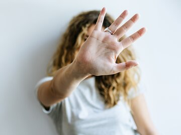 Frau versteckt sich vor ihrer Hand | © GettyImages/F.J. Jimenez