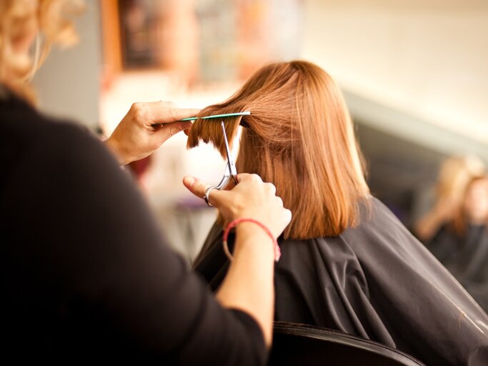 Frau ist beim Friseur und bekommt einen Haarschnitt | © Adobe Stock/ IdeaBug, Inc.