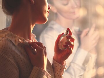 Frau sprüht sich Parfum auf | © AdobeStock/Goffkein