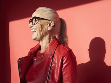 Reife Frau in roter Lederjacke ist glücklich und lacht | © GettyImages/Flashpop