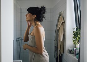 Frau steht im Bad nach einer Dusche