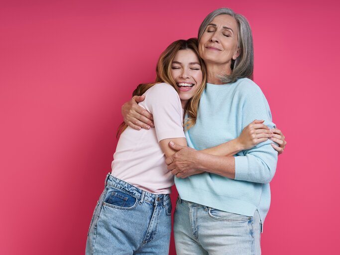 Mutter und Tochter halten sich innig im Arm | © Getty Images/g-stockstudio