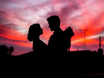 Paar steht im Sonnenuntergang. | © Unsplash / Travis Grossen 