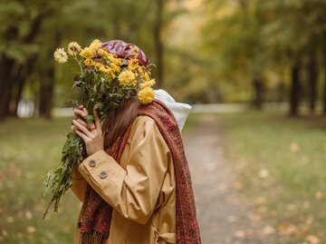 Introvertierte Frau versteckt sich hinter Blumenstrauß | © Adobe Stock/Dzmitry
