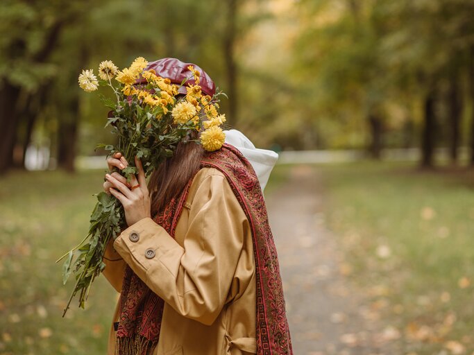 Introvertierte Frau versteckt sich hinter Blumenstrauß | © Adobe Stock/Dzmitry