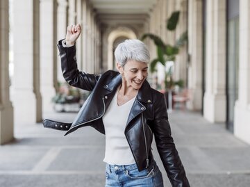 Frau mit grauen Haaren tanzt glücklich  | © GettyImages/	COROIMAGE
