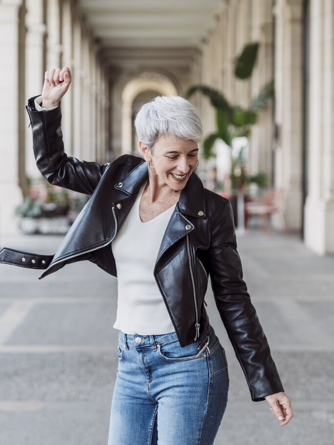 Frau mit grauen Haaren tanzt glücklich  | © GettyImages/	COROIMAGE