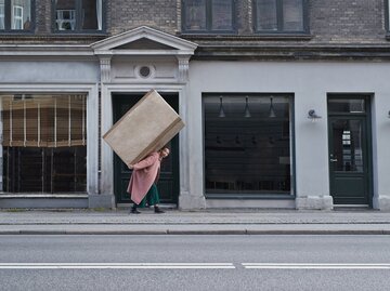 Frau trägt großes Paket | © GettyImages/Klaus Vedfelt