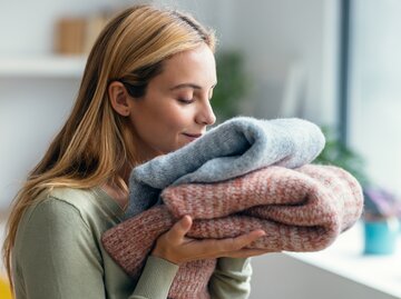 Frau riecht an frisch gewaschener Kleidung | © AdobeStock/nenetus