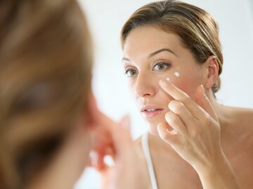 Frau trägt Creme auf  | © AdobeStock/goodluz